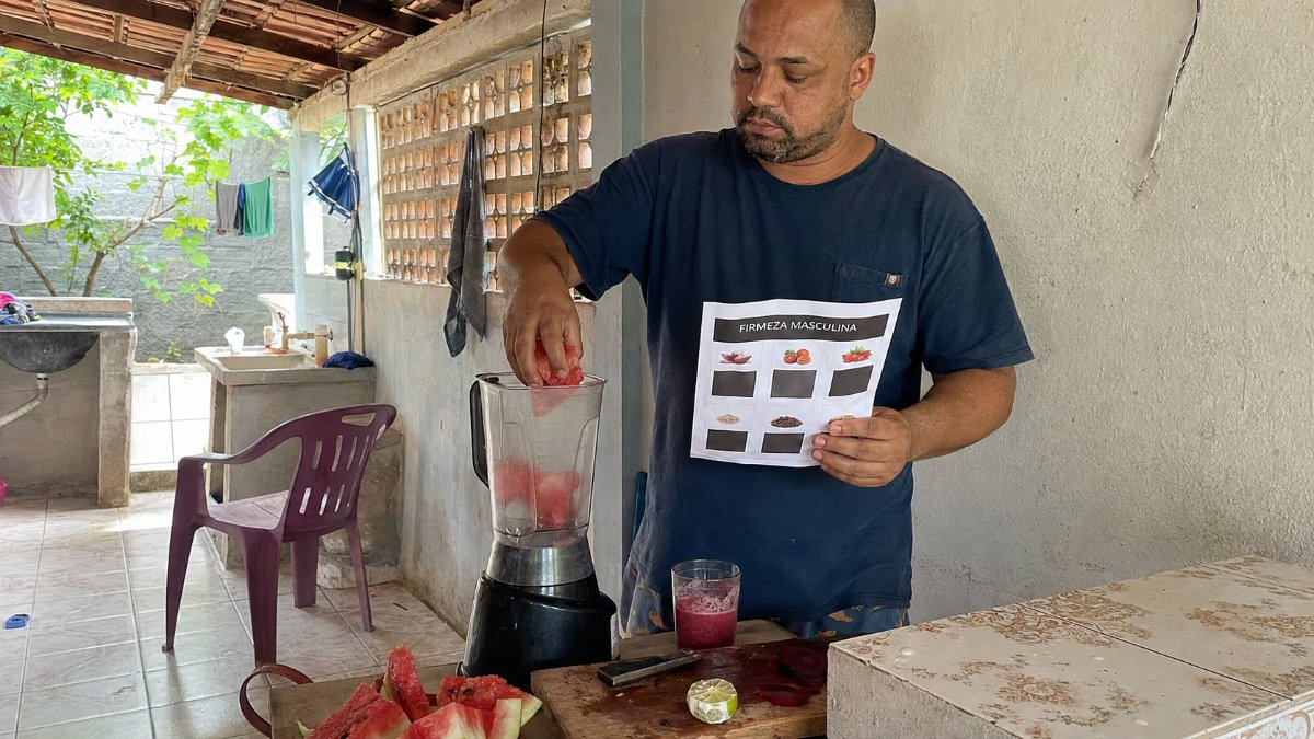 Hombre colocando los ingredientes en la licuadora según la lista de la guía